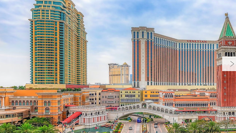 Cotai Strip skyline in Macau illuminated at night with digital blockchain security token nodes overlaying luxury hotel developments.