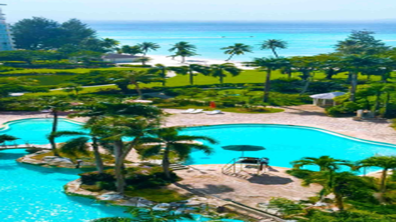 Panoramic view of Saipan Garapan coastline with glowing US Dollar digital security token nodes overlaid on luxury beachfront resorts.