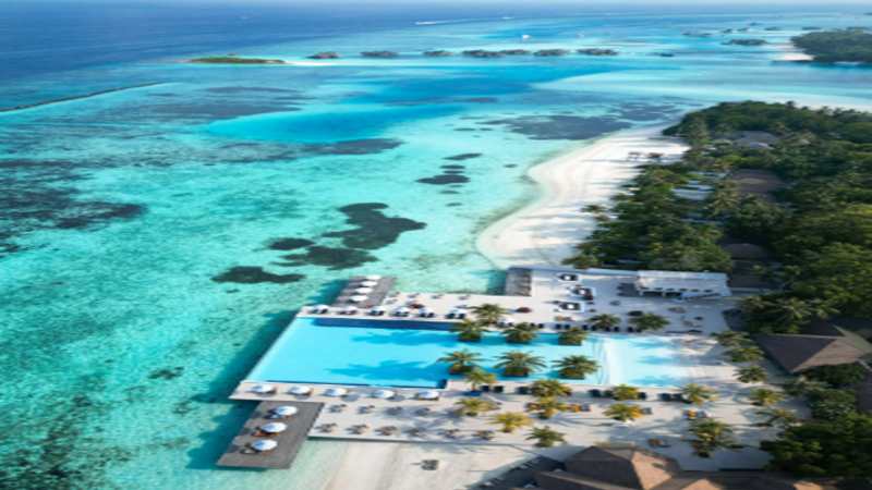 Aerial view of luxury overwater bungalow resort in the Maldives with digital blockchain network overlay graphics.